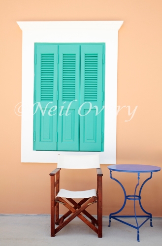 Shuttered window, chair and table, Kastellorizo, Greece