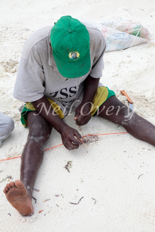 Fisherman repairs his net, Jambiani, Zanzibar